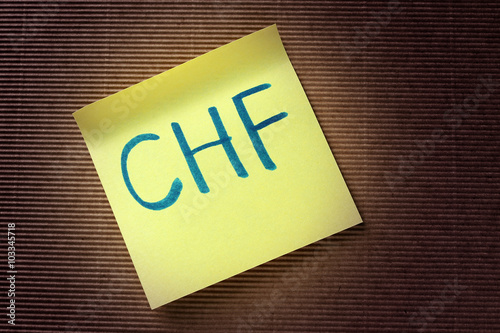 CHF (Swiss Franc) acronym on yellow sticky note