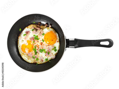 Fried eggs in pan isolated on white background.