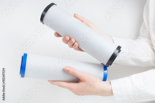 two water filter cartridges in human hands 