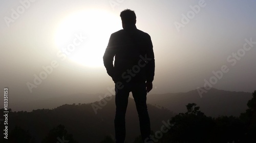 4K Man watching the sunset on the mountain 