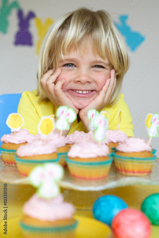 Funny little boy with cupcakes in Easter scene Funny little boy with cupcakes in Easter scene