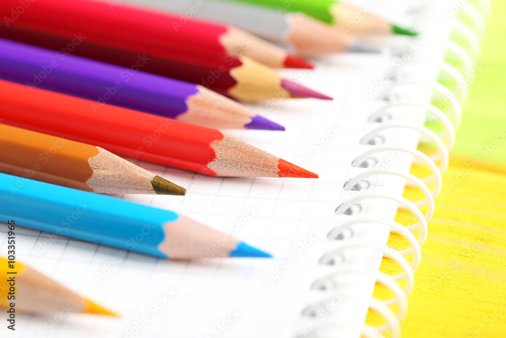 Drawing colourful pencils with notebook on a wooden background Drawing colourful pencils with notebook on a wooden background