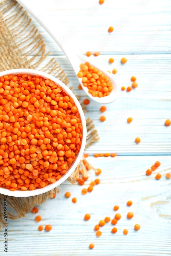 Red lentils in bowl on a blue wooden table Red lentils in bowl on a blue wooden table