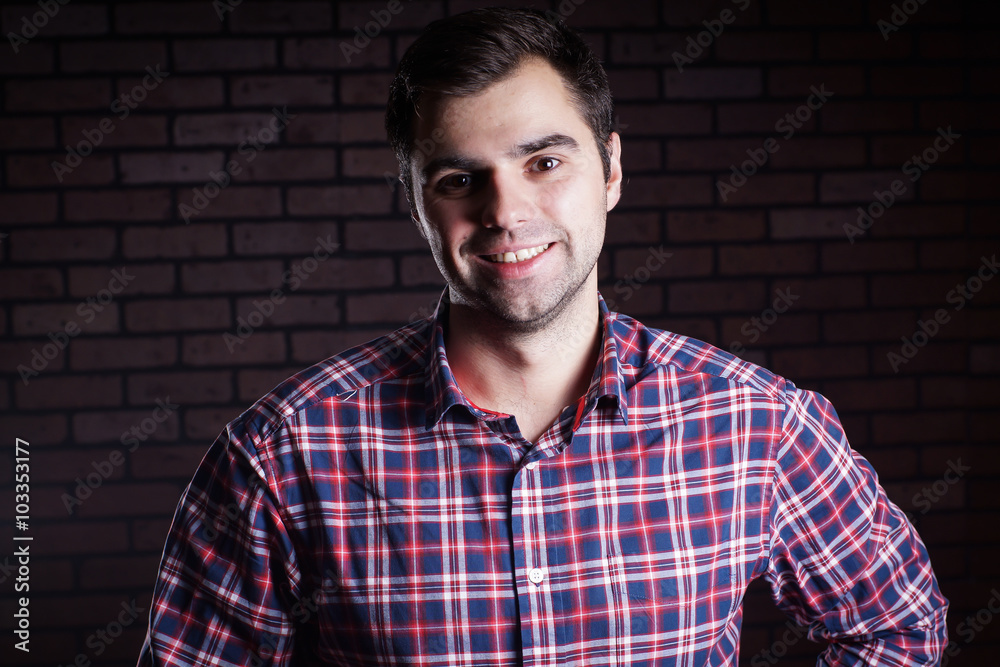 Portrait of cute funny young guy in a plaid shirt/ Cute young guy in a plaid shirt smiling Portrait of cute funny young guy in a plaid shirt/ Cute young guy in a plaid shirt smiling