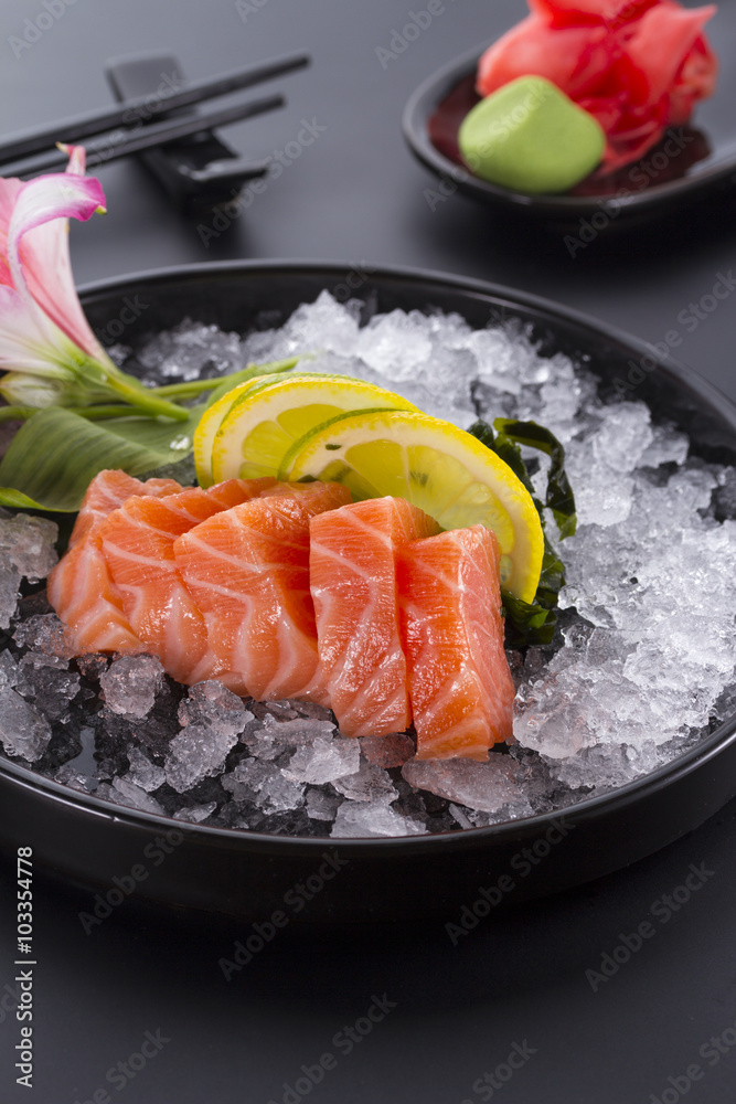 Salmon raw sasimi with ice on a black background