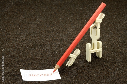 Akrobatische Figuren aus Holz schreiben das Wort Success