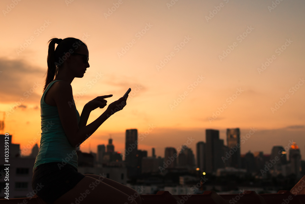 Fototapeta premium Woman using her smart phone in the city. 