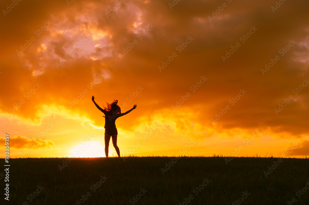 Woman in a beautiful sunset feeling free.