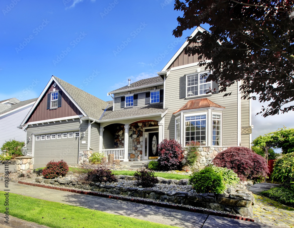 Modern home with navy blue door and decorative front yard.