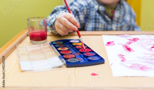 Small child painting with watercolors