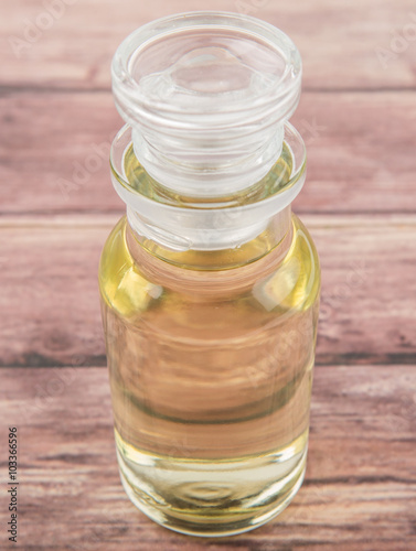 Apple vinegar in glass vial over wooden background