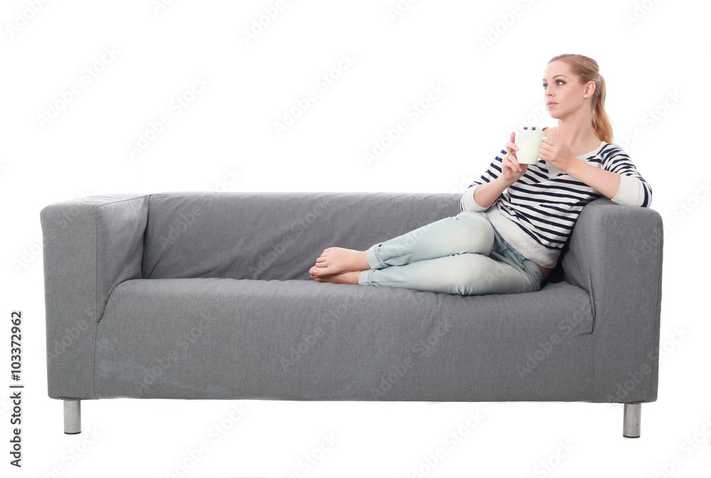 a pretty blonde lady wearing casual clothes, lounging on a grey sofa. isolated on a white background. a pretty blonde lady wearing casual clothes, lounging on a grey sofa. isolated on a white background.