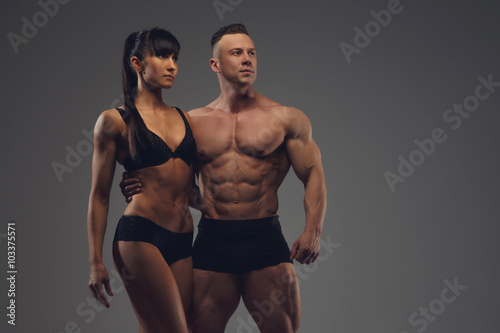 Fitness couple isolated on a grey background.