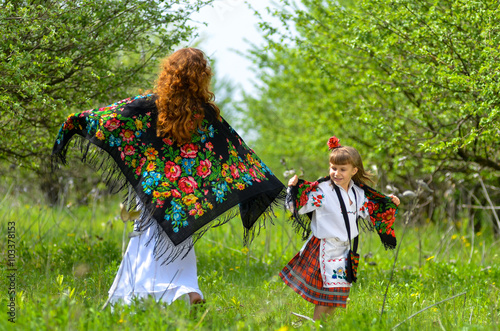 Young beautiful mother walking with her daughter in the garden