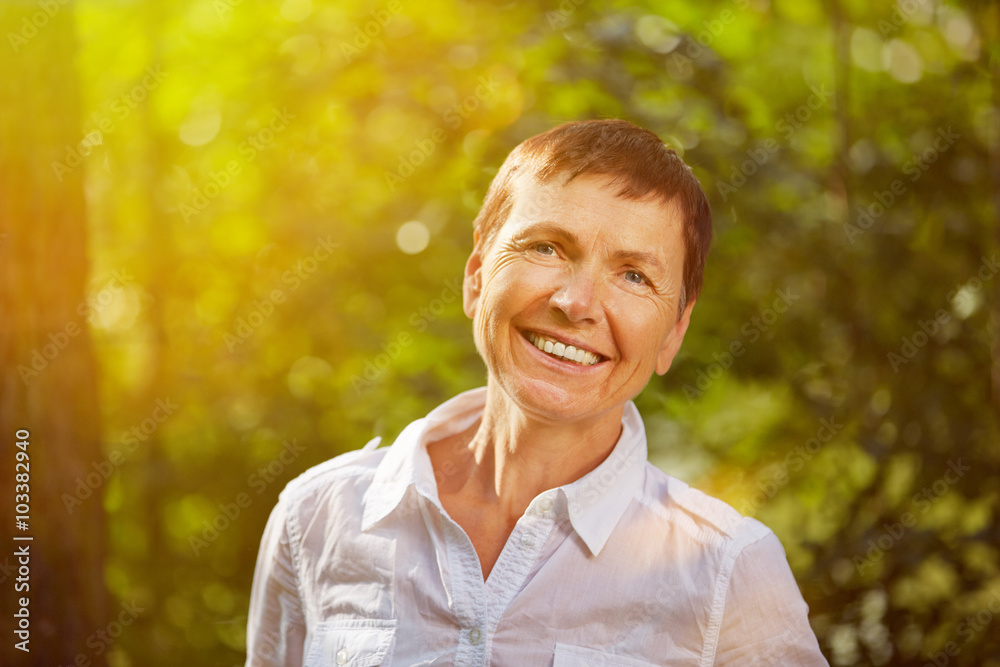 Seniorin steht im Sommer in der Sonne Seniorin steht im Sommer in der Sonne