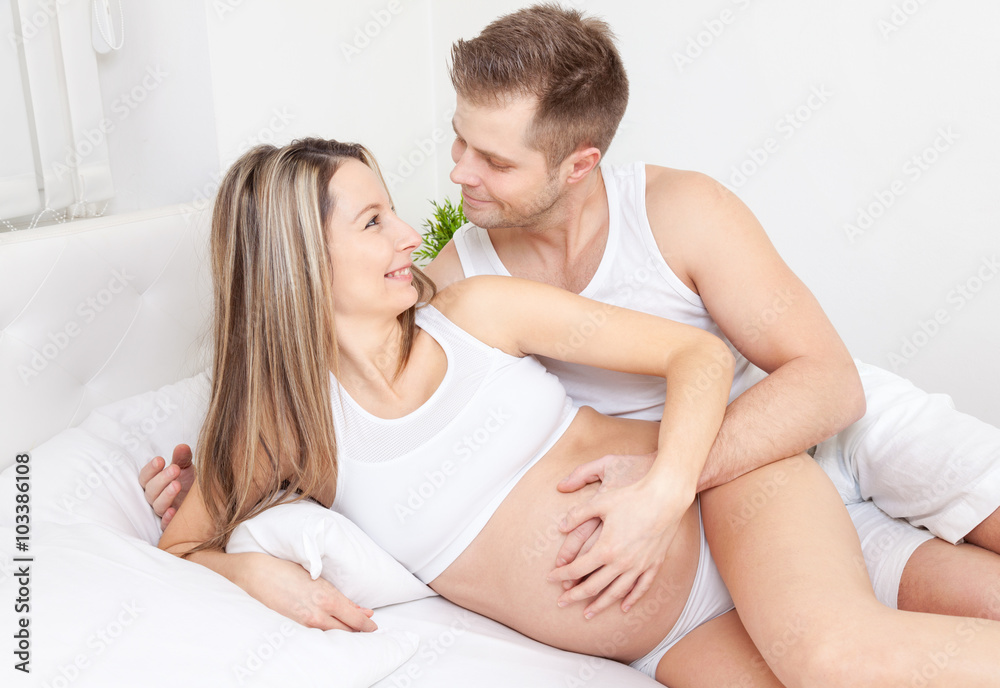 Delighted young parents in bed expecting a baby Delighted young parents in bed expecting a baby