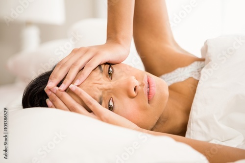 Frowning brunette in bed photo