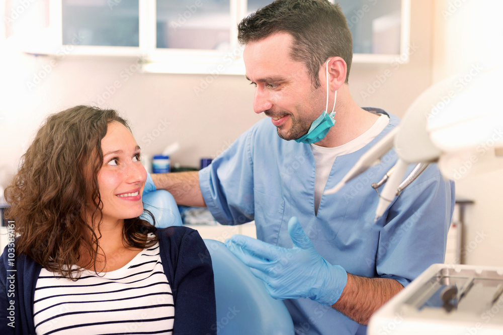 Fototapeta premium Young attractive woman being cured by a dentist