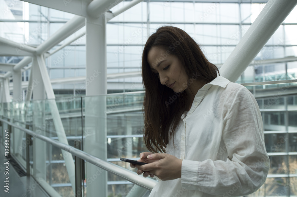 Women are using a smart phone in the modern building Women are using a smart phone in the modern building