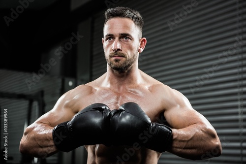 Determined shirtless man with boxe gloves © WavebreakMediaMicro