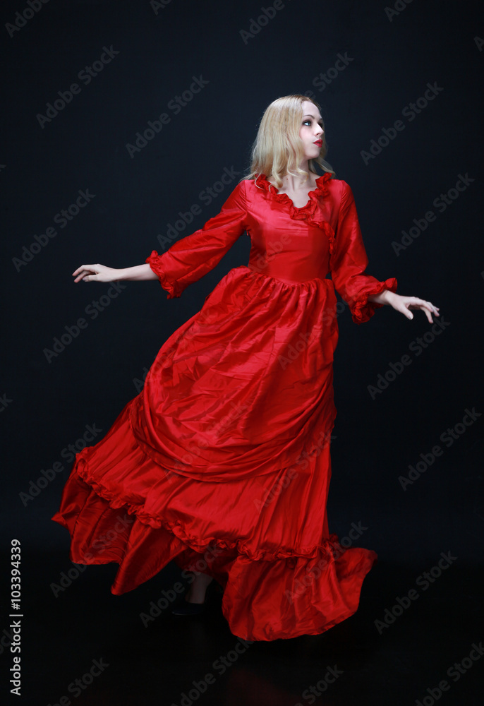 full length portrait of a beautiful blonde woman wearing a historical red silk, victorian era ball gown. full length portrait of a beautiful blonde woman wearing a historical red silk, victorian era ball gown.