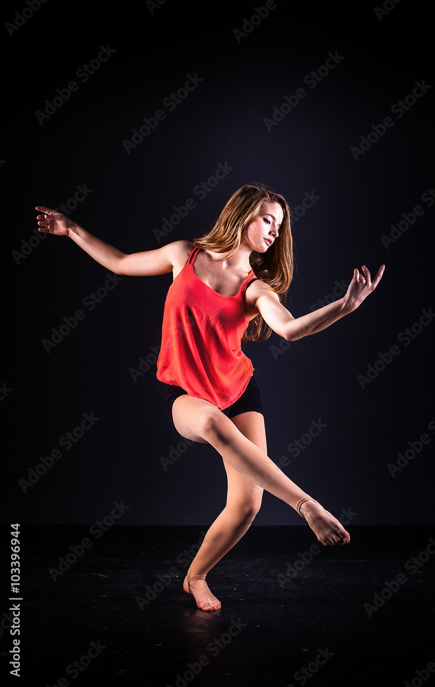 beautiful ballet dancer posing on black studio background