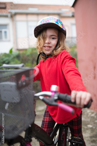 Little girl with her bicycle outdoors