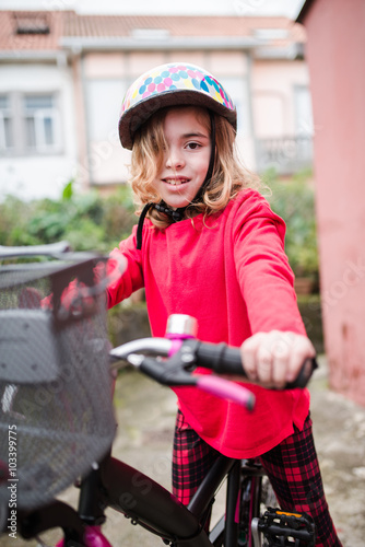 Little girl with her bicycle outdoors
