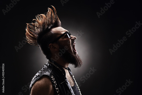 Punk rocker shouting on dark background photo