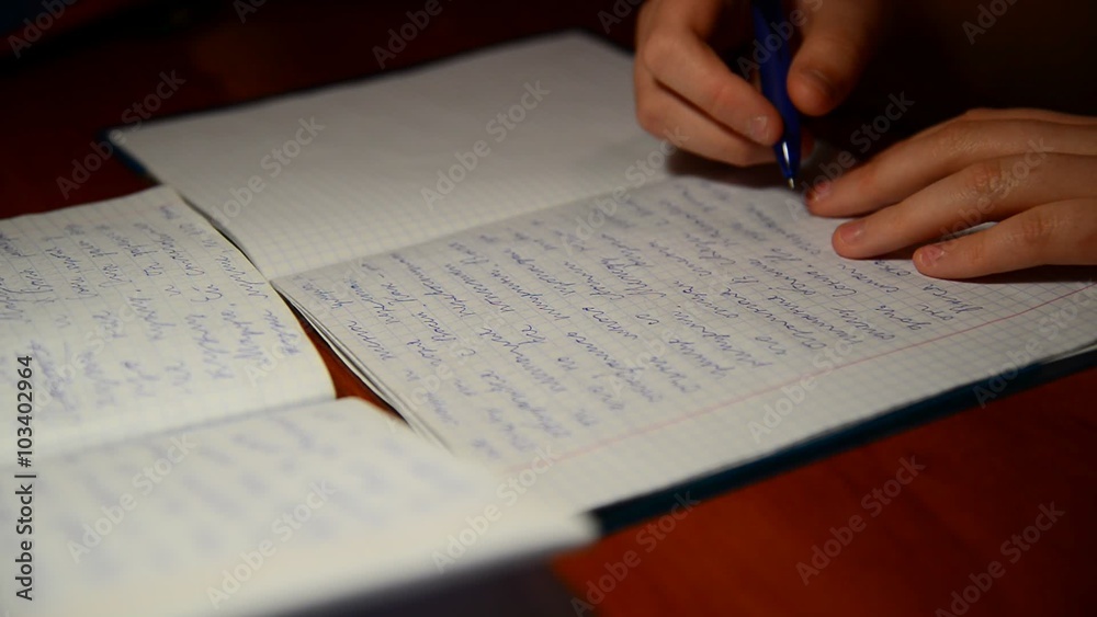 boy writes in notebook homework on Russian language boy writes in notebook homework on Russian language