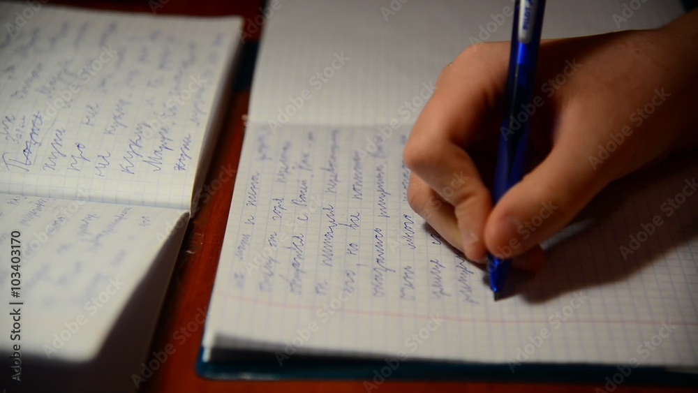  boy writes in notebook homework on Russian language