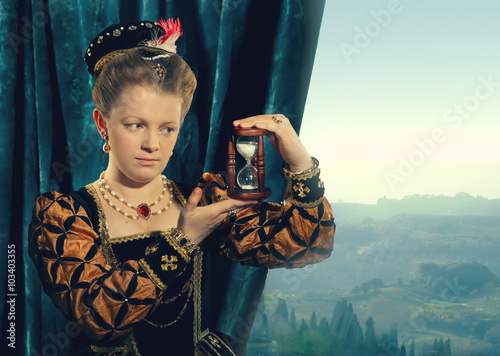 Little blonde girl wearing renaissanse velvet dark blue dress