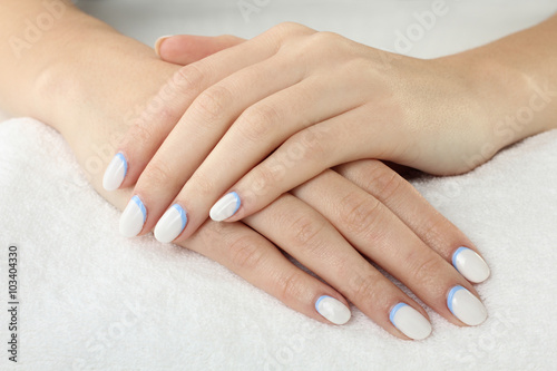 woman with manicure on white fluffy towel closeup