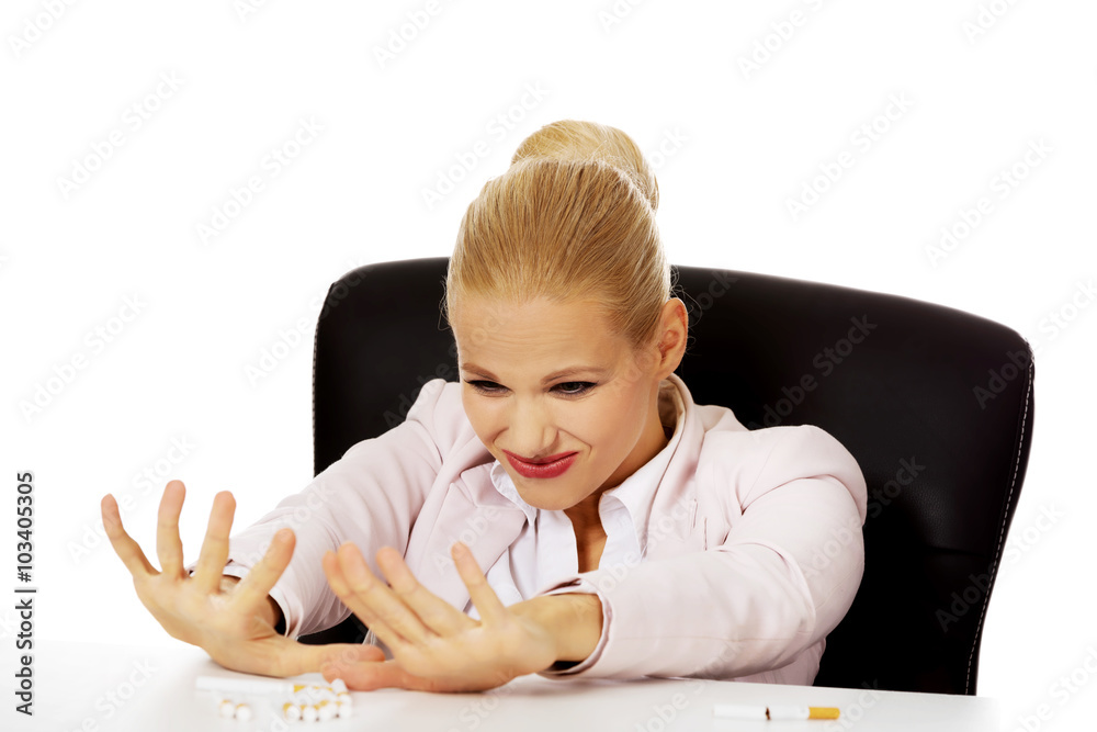 Business woman sitting behind the desk don't want to smoke Business woman sitting behind the desk don't want to smoke