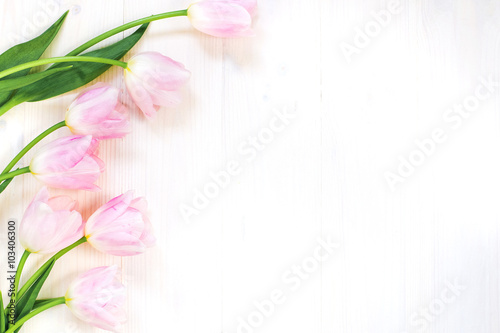 Fototapeta Naklejka Na Ścianę i Meble -  Tender pink tulips on white wooden background. Top view. Spring greeting card.