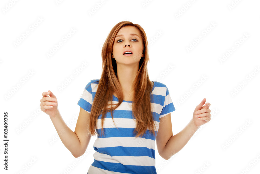 Teenage woman with outstretched arms looking up Teenage woman with outstretched arms looking up