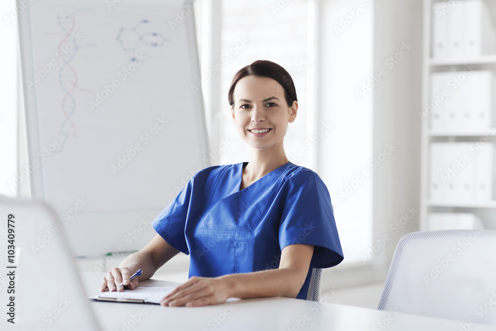 happy female doctor or nurse writing to clipboard happy female doctor or nurse writing to clipboard