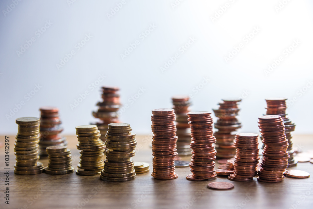 A wooden doll man with his savings, gold coin. All composed with thai baht twenty-five cent, fifty cent, thai baht and yuan A wooden doll man with his savings, gold coin. All composed with thai baht twenty-five cent, fifty cent, thai baht and yuan