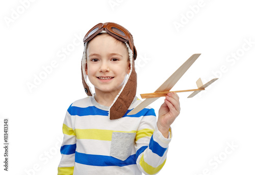 happy little boy in aviator hat with airplane