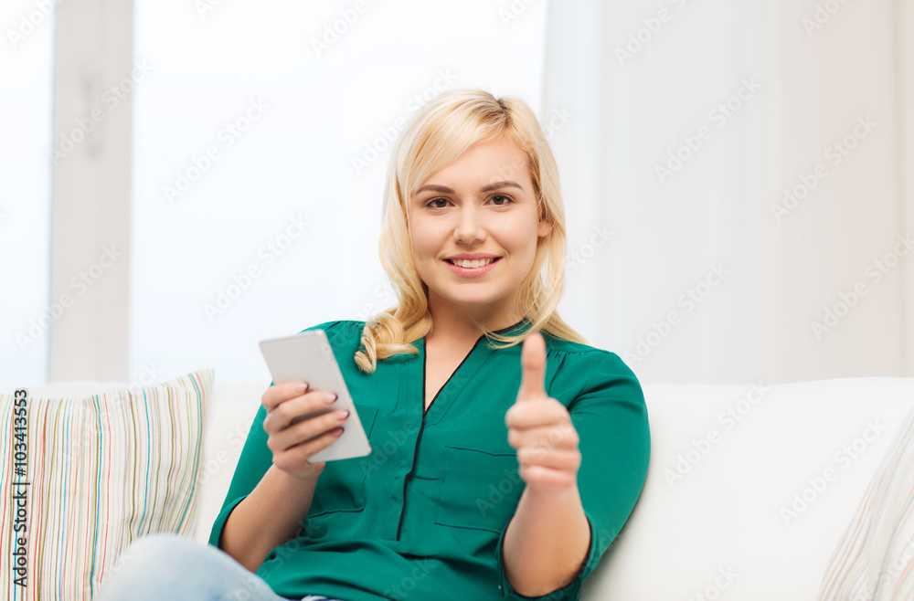woman with smartphone showing thumbs up at home woman with smartphone showing thumbs up at home