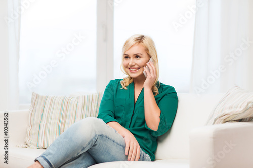 happy young woman calling on smartphone at home