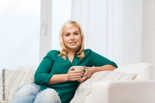 happy woman  with cup of tea or coffee at home © Syda Productions