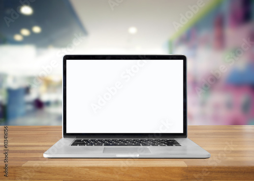 Laptop with blank screen on table. interior background, blurred