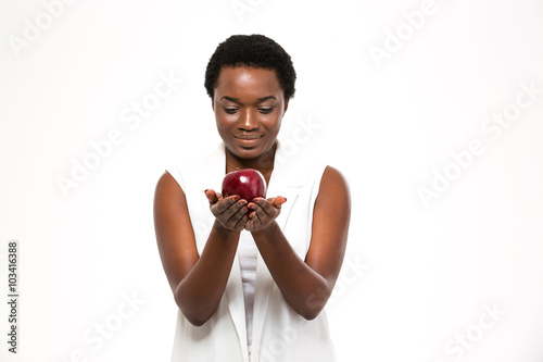 Attractive cheerful african woman holding big red apple on palms