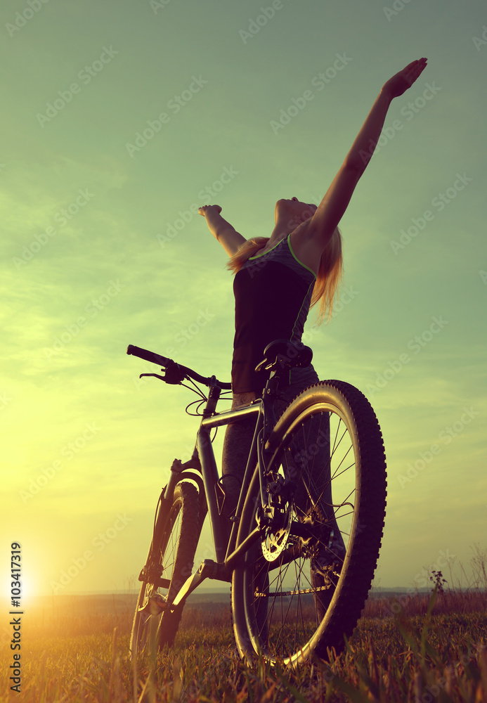Obraz premium Girl on a bicycle in the sunset
