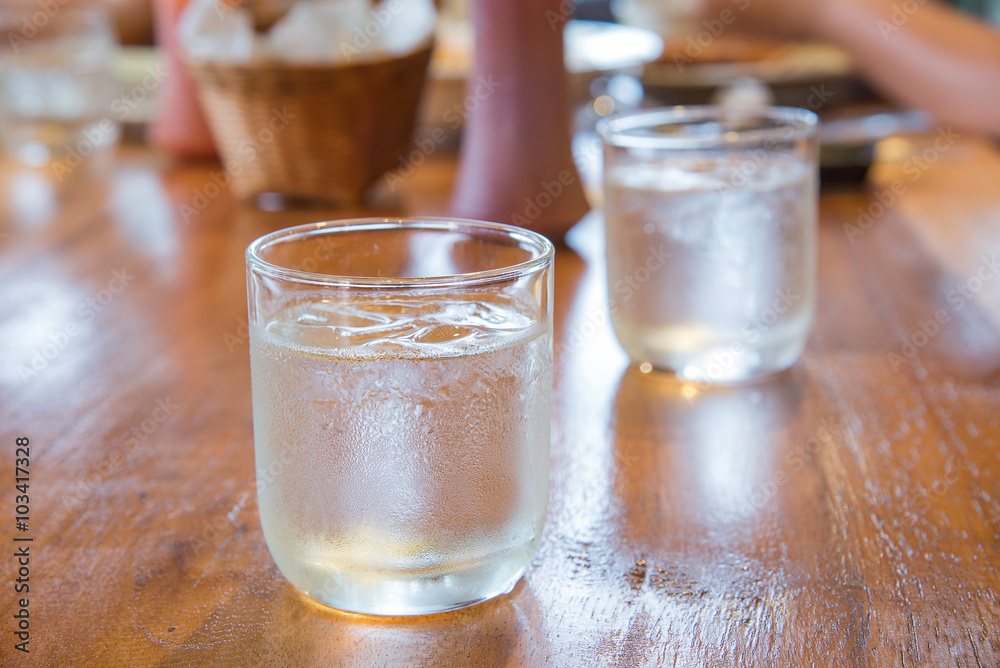 Glass water with ice on wooden table. Glass water with ice on wooden table.