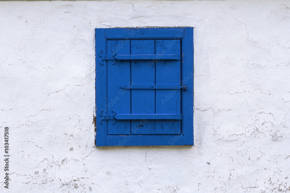 Blue window with closed wooden blind