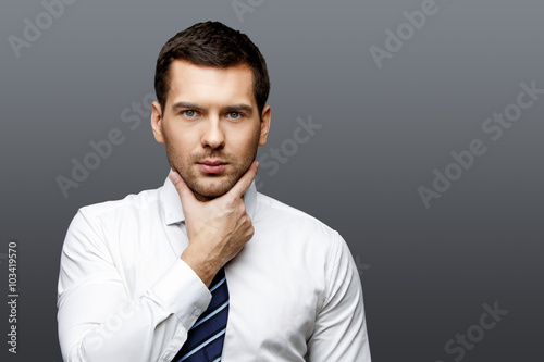 Handsome stylish businessman on grey background
