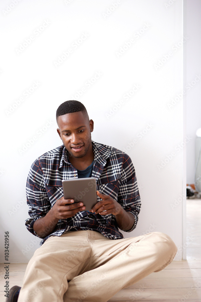 Young african guy using digital tablet at home Young african guy using digital tablet at home