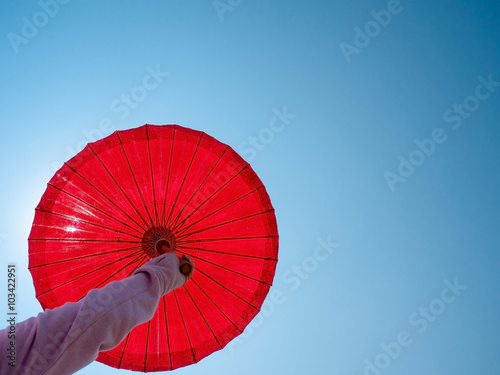 umbrella on woman hand against sunny blue sky